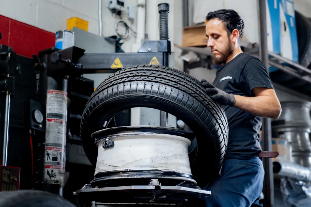 mechanic installing tire on wheel